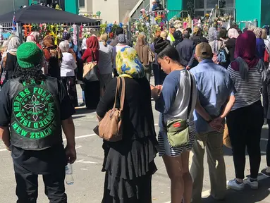 Orang-orang membentuk rantai manusia untuk melindungi jemaah salat Jumat di Hagley Park luar masjid Al-Noor, di Christchurch, Selandia Baru, Jumat (22/3). Ibadah itu digelar sepekan selepas penembakan brutal di kota Christchurch. (Sue Teodoro via REUTERS)
