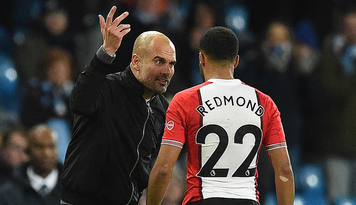 Pelatih Manchester City, Pep Guardiola saat memarahi gelandang Southampton Nathan Redmond di Stadion Etihad di Inggris (29/11). Guardiola mengatakan Southampton memiliki beberapa pemain bertalenta luar biasa, salah satunya Redmond. (AFP Photo/Oli Scarff)