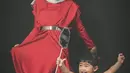 Pemotretan kedua Ria Ricis turut ditemani oleh sang buah hati, Moana. Mereka kompak kenakan dress warna merah. [@@askar_photography]