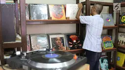 Iyan (56) merapikan piringan hitam dagangannya, Jakarta, Selasa (30/5). Piringan hitam klasik yang dijual berkisar Rp25ribu - Rp400ribu tersebut masih menjadi daya tarik bagi sejumlah penikmat musik di Tanah Air. (Liputan6.com/Immanuel Antonius)