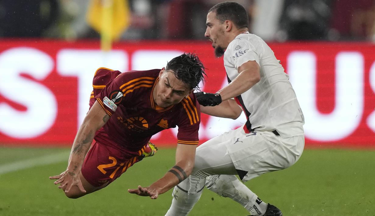 Pemain AS Roma, Paulo Dybala, terjatuh saat berusaha melewati pemain AC Milan, Ismael Bennacer, pada leg kedua perempat final Liga Europa di Stadion Olimpico, Roma, Jumat (19/4/2024). (AP Photo/Andrew Medichini)
