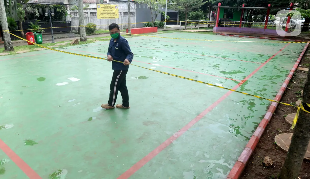 Garis pembatas larangan masuk dipasang di Taman Merak, Limo, Depok, Senin (25/1/2021). Pembatasan dan penutupan taman tersebut dilakukan dalam rangka Pemberlakuan Pembatasan Kegiatan Masyarakat (PPKM) untuk mengendalikan pandemi virus corona (Covid-19). (merdeka.com/Arie Basuki)