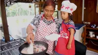 Susi Pudjiastuti saat memasak ikan layur bersama cucunya. (dok. YouTube Susi Pudjiastuti)