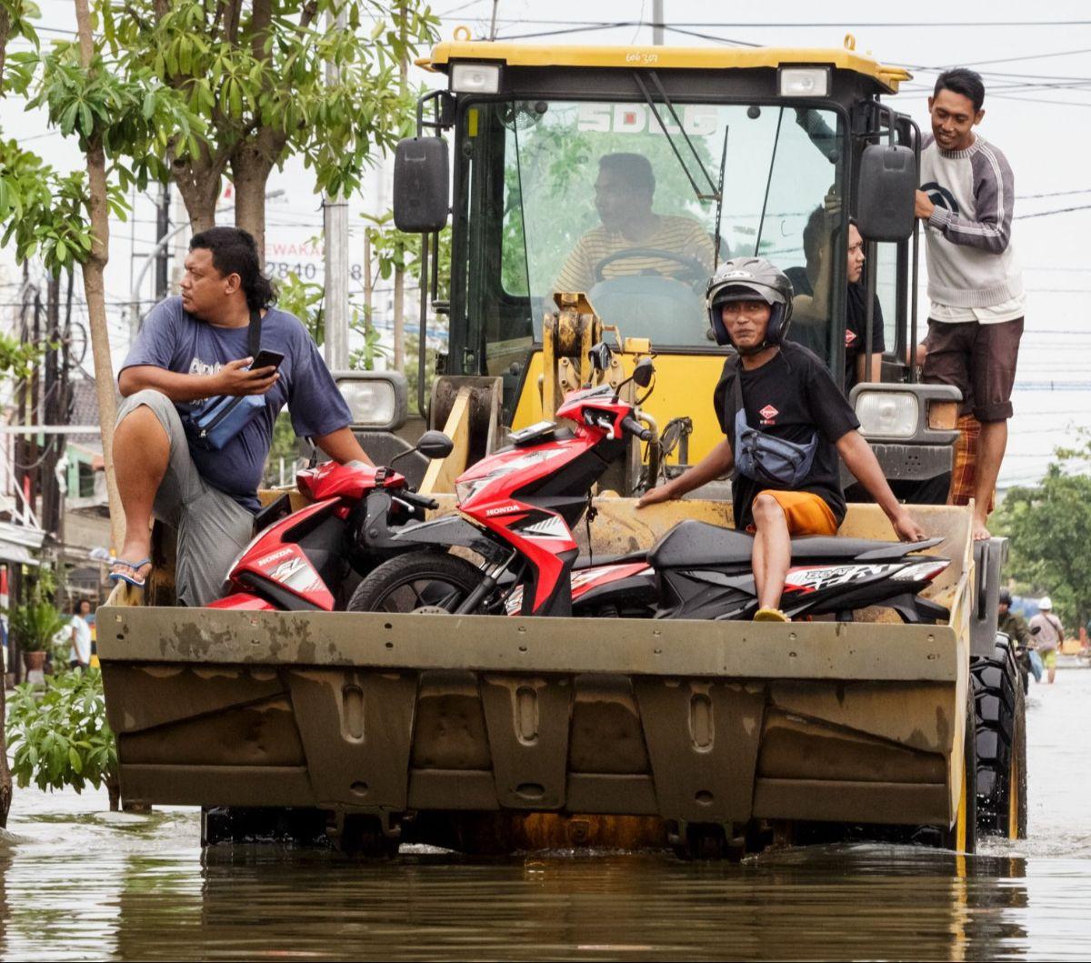 Sejumlah pengendara sepeda motor dievakuasi menggunakan buldoser saat banjir merendam salah satu kawasan di Kota Semarang, Jawa Tengah, Jumat (15/3/2024). Banjir yang terjadi sejak Kamis (14/3) dini hari masih merendam sejumlah titik di Ibu Kota Jawa Teng