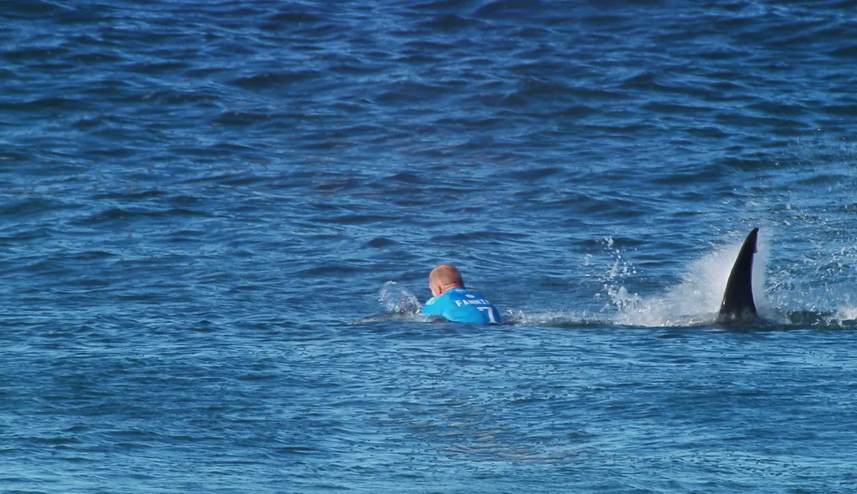 Peselancar Australia, Mick Flanning saat diserang seekor hiu di teluk Jeffrey's Afrika Selatan, (19/7/2015). Mick terjatuh dari papannya setelah diserang hiu dalam final kompetisi surfing dunia. (REUTERS/World Surf League)