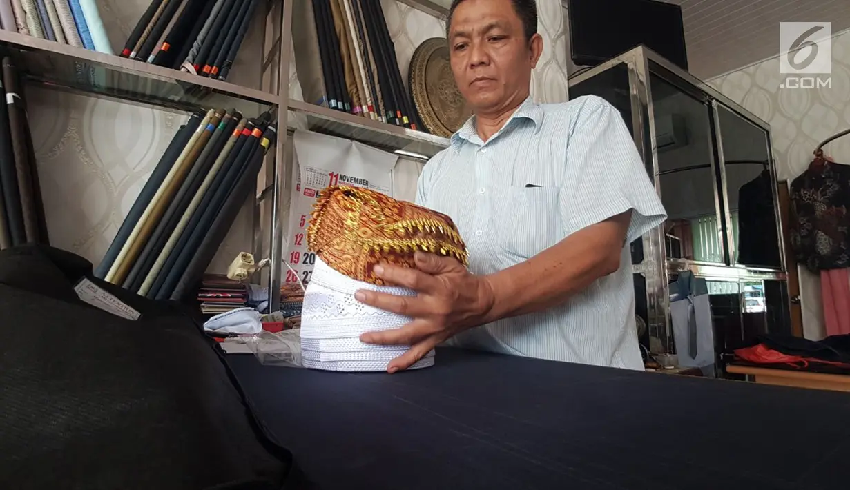Pekerja merapihkan aksesoris yang akan dikenakan para Raja Adat saat ngunduh mantu Kahiyang-Bobby di Medan, Kamis (23/11). Untuk busana para Raja, pihak keluarga telah mempercayakan pada penjahit Safry. (Liputan6.com/Aditya Eka)