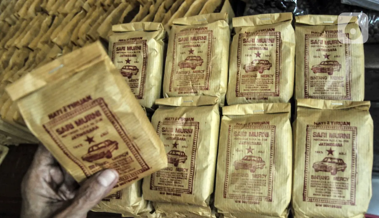 Pekerja menunjukkan kopi yang siap dipasarkan di toko kopi Sari Murni, Jatinegara, Jakarta Timur, Selasa (4/1/2021). Pengelola toko, Rudi mengaku penjualan kopi di masa pandemi COVID-19 mengalami penurunan yang signifikan, yakni hingga 60 persen. (merdeka.com/Iqbal S. Nugroho)