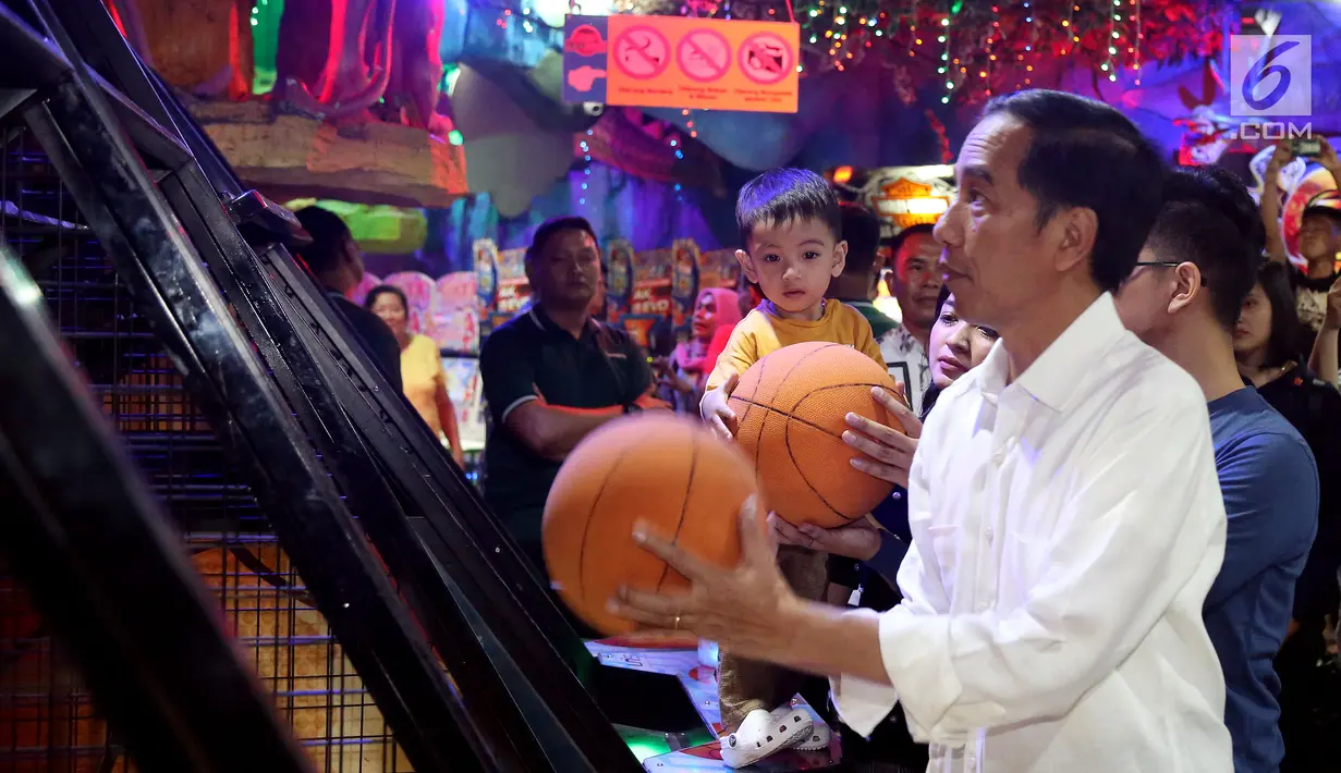 Presiden Joko Widodo dan cucu Jan Ethes Srinarendra menyempatkan diri bermain basket di Sun Plaza Medan, Sumatera Utara, Jumat (24/11). Jokowi tiba di lokasi mengenakan kemeja putih lengan panjang dan celana hitam. (Liputan6.com/Johan Tallo)