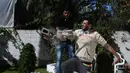 Aksi Mohamed Barka, pria yang dijuluki "Super Hero" asal Palestina yang menjadikan lengannya sebagai bantalan untuk menghancurkan batu bata beton di Deir Al-Balah, Gaza Tengah, Kamis (4/2). (MOHAMMED ABED/AFP)