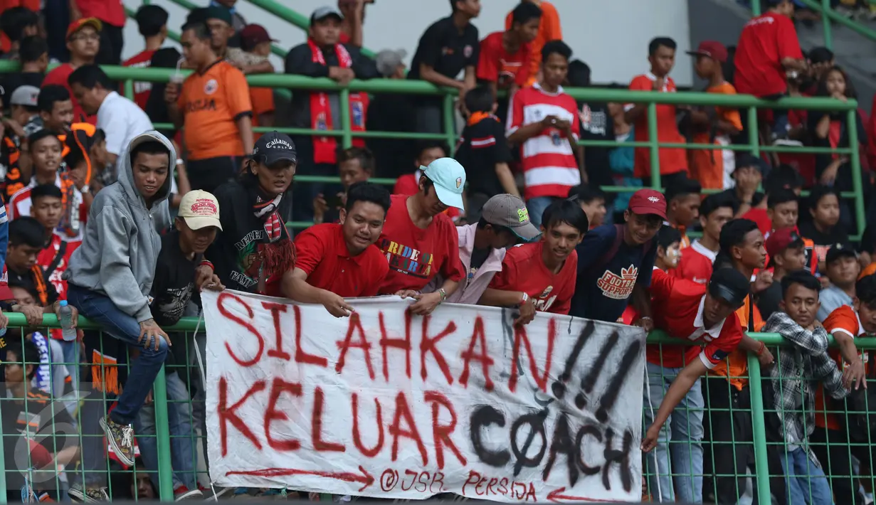 Suporter membentangkan spanduk protes usai menyaksikan laga Persija melawan Mitra Kukar pada lanjutan Liga 1 Indonesia di Stadion Patriot Candrabhaga, Bekasi, Minggu (14/5). Laga kedua tim berakhir imbang 1-1. (Liputan6.com/Helmi Fithriansyah)