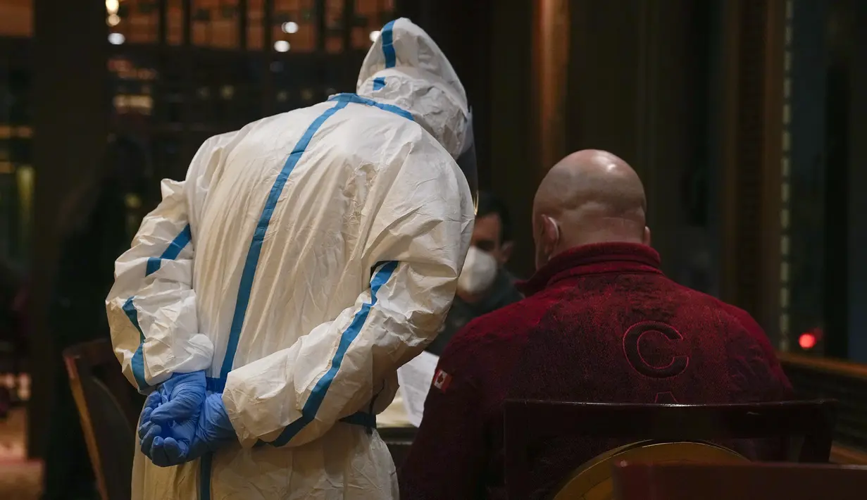 Seorang pramusaji yang mengenakan pakaian pelindung diri atau hazmat menerima pesanan dari anggota tim Olimpiade Kanada di sebuah restoran di dalam Hotel Shangri-La pada Olimpiade Musim Dingin 2022, 16 Februari 2022, di Beijing. (AP Photo/Jae C.Hong)