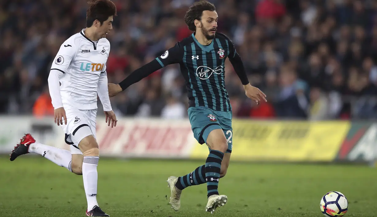 Pemain Southampton, Manolo Gabbiadini (kanan) mencoba melewati pemain Swansea City, Ki Sung-yueng pada lanjutan Premier League di Liberty Stadium, Swansea, (8/5/2018). Swasea City kalah dari Soton 0-1.  (Nick Potts/PA via AP)