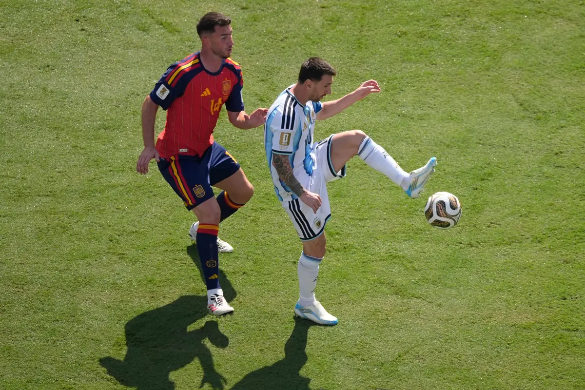 Pemain Spanyol Aymeric Laporte (kiri) mengawal pemain Argentina Lionel Messi