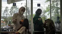 Sejumlah calon penumpang menjalani tes swab PCR di Stasiun Pasar Senen, Jakarta, Jumat (24/12/2021). Mulai hari ini, penumpang kereta wajib menunjukkan hasil negatif tes PCR. (Liputan6.com/Faizal Fanani)