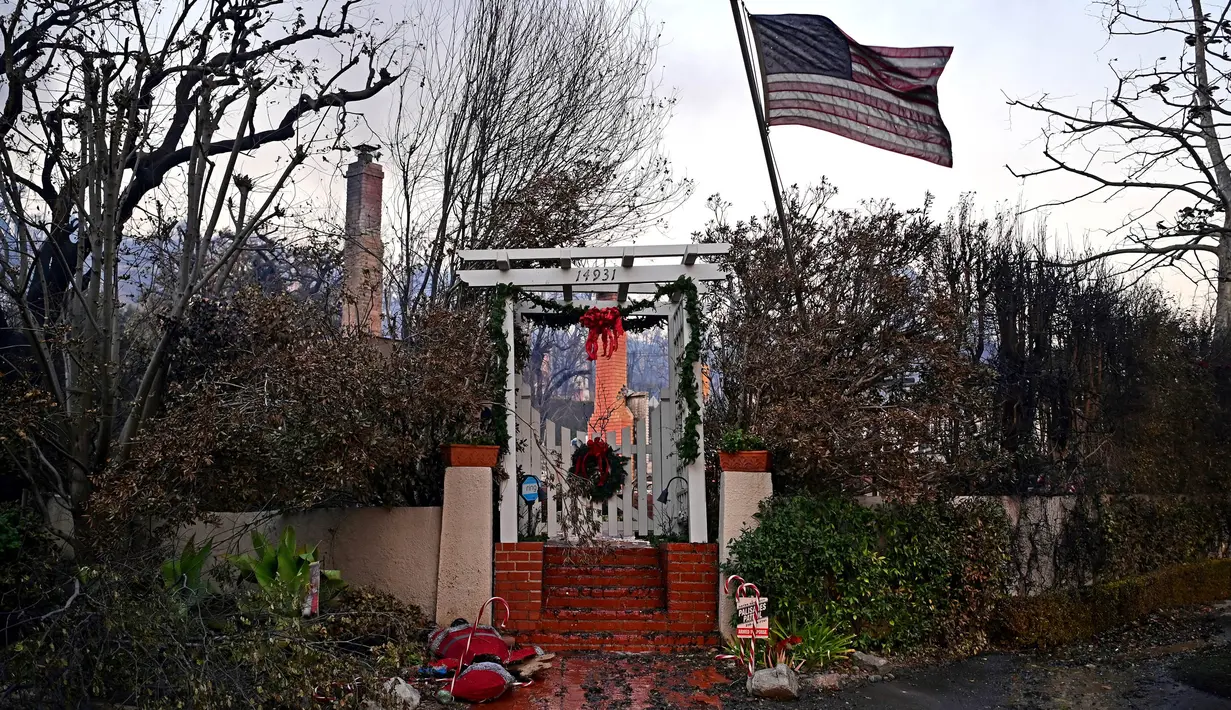 Bendera Amerika Serikat (AS) dan dekorasi Natal terlihat di sisa-sisa rumah setelah terjadinya Kebakaran Palisades di Pacific Palisades, California, pada 8 Januari 2025. (AGUSTIN PAULLIER/AFP)
