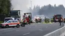Petugas penyelamat berada di lokasi kecelakaan di Muenchberg, Jerman, Senin (3/7). Sebuah bus wisata menabrak sebuah truk dan terbakar. (AP Photo)
