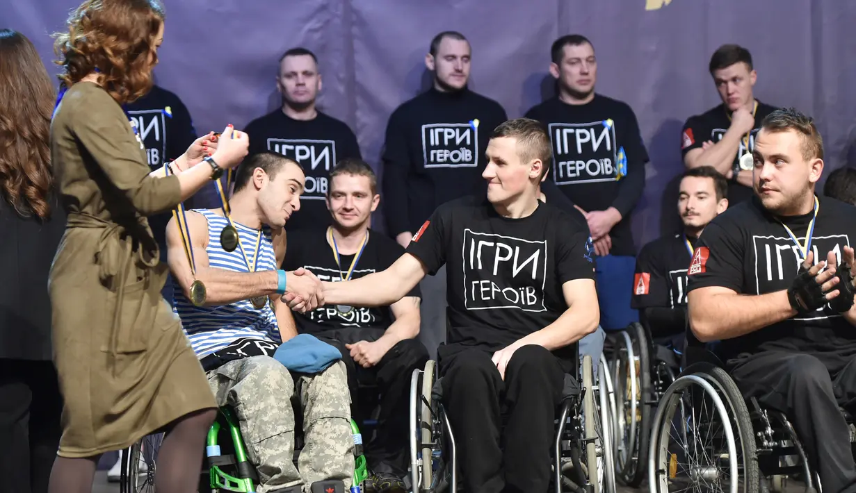 Para peserta bersalaman usai mengikuti kompetisi final CrossFit "Game of Heroes" di Kiev, Ukraina (24/12). Kompetisi ini diikuti oleh lima belas tentara Ukraina yang cacat akibat pertempuran dengan pihak separatis pro Rusia. (AFP/Sergei Supinsky)