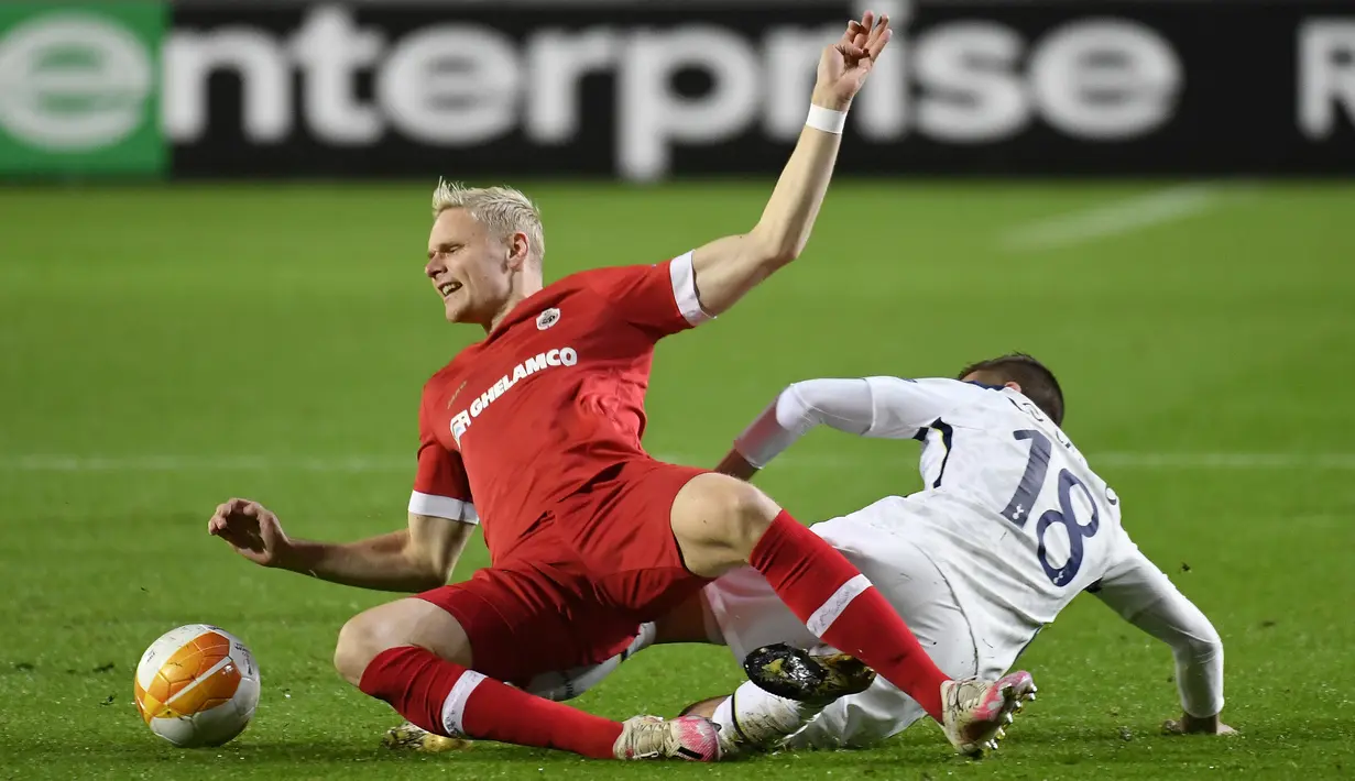 Gelandang Tottenham, Giovani Lo Celso, berebut bola dengan gelandang Antwerp, Simen Juklerod, pada laga lanjutan Liga Eruopa 2020/2021 di BosuilStadion, Jumat (30/10/2020) dini hari WIB. Tottenham kalan 0-1 oleh Antwerp. (AFP/John Thys)