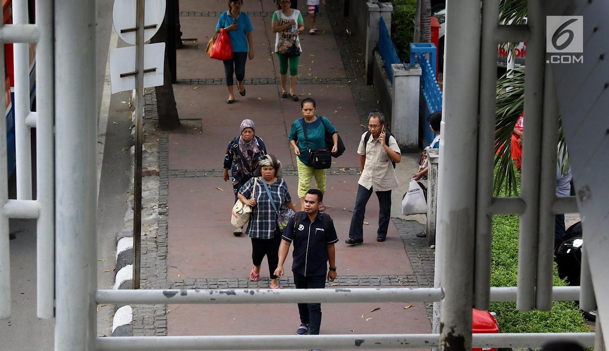 Pejalan kaki melintasi trotoar di kawasan MH Thamrin, Jakarta, Selasa (6/3). Sebagai bagian penataan jalan dan trotoar, Pemprov DKI menegaskan akan menyapu bersih PKL di sepanjang kawasan Sudirman – MH Thamrin. (Liputan6.com/Immanuel Antonius)