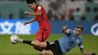 Pemain Uruguay yang juga menjadi tumpuan Real Madrid musim ini, Federico Valverde bahkan harus turun membantu pertahanan untuk menghalau laju penyerang Korea Selatan, Lee Kang-in. (AP Photo/Frank Augstein)