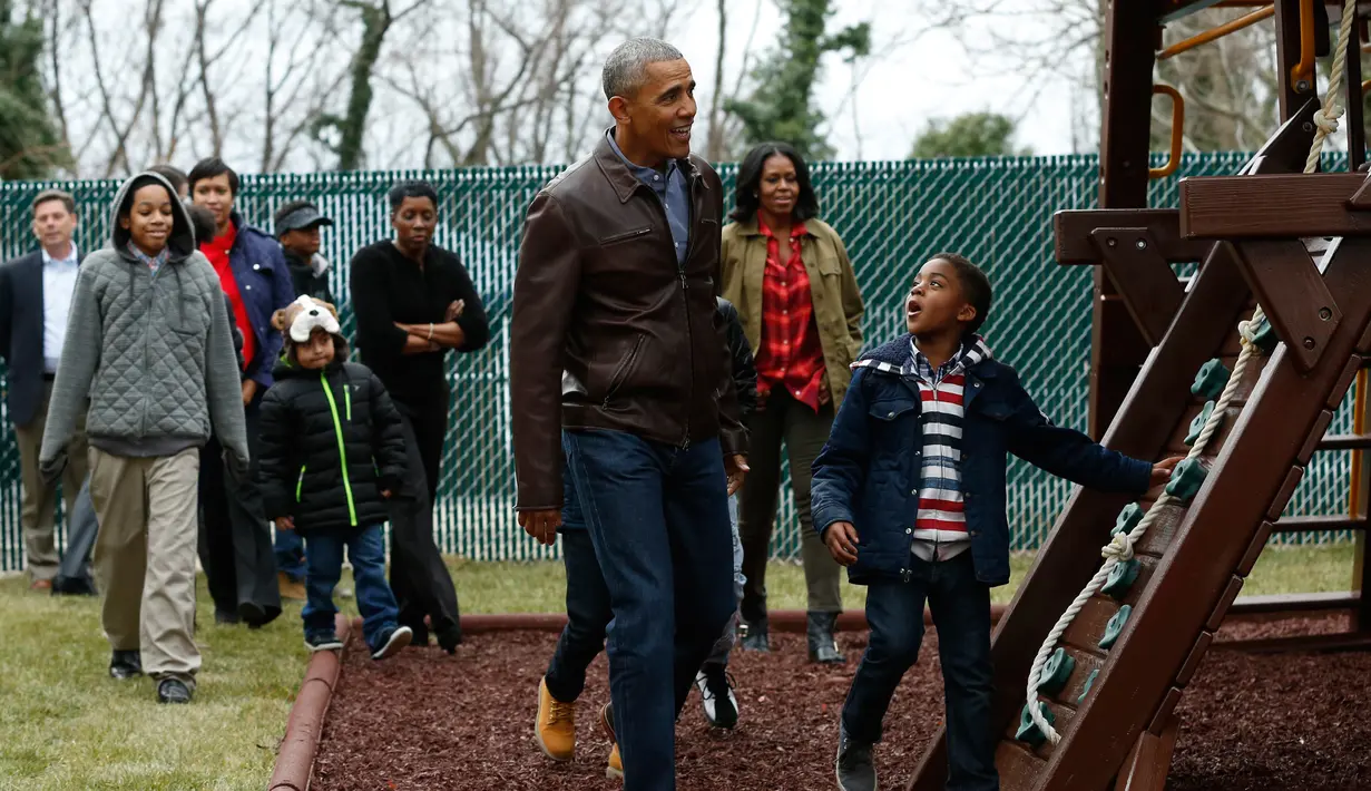 Presiden AS Barack Obama bersama sejumlah bocah saat tiba di wahana bermain di Washington DC, AS, Selasa (16/1). Obama menyumbangkan wahana bermain milik kedua putrinya yang dipasang di luar Oval Office. (AFP PHOTO / YURI GRIPAS)