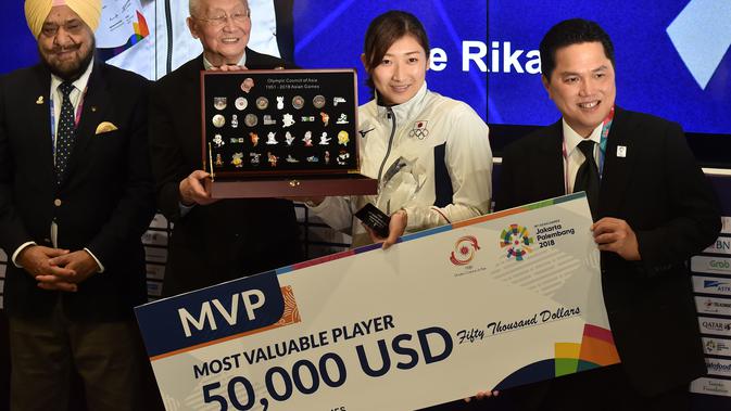 Perenang Jepang Rikako Ikee (dua kanan) didampingi Ketua Inasgoc Erick Thohir (kanan) saat penyerahan hadiah 50.000 USD sebagai Most Valuable Player (MVP) Asian Games 2018 di Jakarta, Minggu (2/9). (Arief Bagus/AFP)