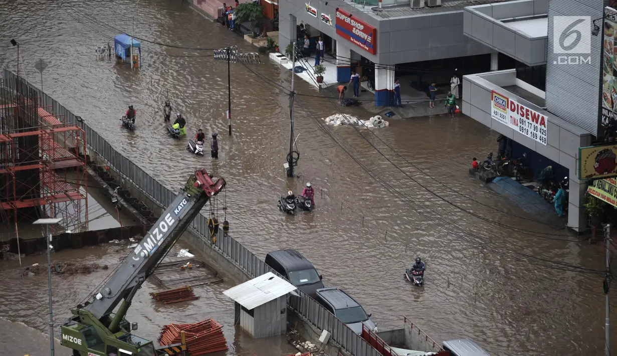 Pengendara sepeda motor mendorong kendaraannya akibat banjir di Jalan Boulevard Barat Raya, Kelapa Gading, Jakarta Utara, Kamis (15/2). Hujan lebat mengakibatkan kawasan tersebut kebanjiran. (Liputan6.com/Arya Manggala)