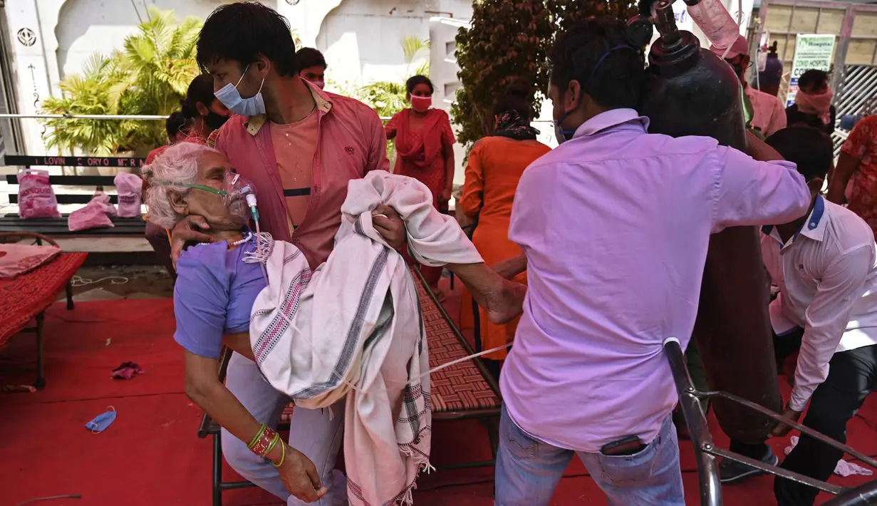 Anggota keluarga membawa pasien yang bernapas dengan bantuan oksigen yang disediakan oleh Gurdwara, tempat ibadah untuk Sikh, di bawah tenda yang dipasang di sepanjang pinggir jalan di Ghaziabad, Selasa (4/5/2021). Amukan tsunami COVID-19 di India memunculkan kelangkaan oksigen (Tauseef MUSTAFA/AFP)