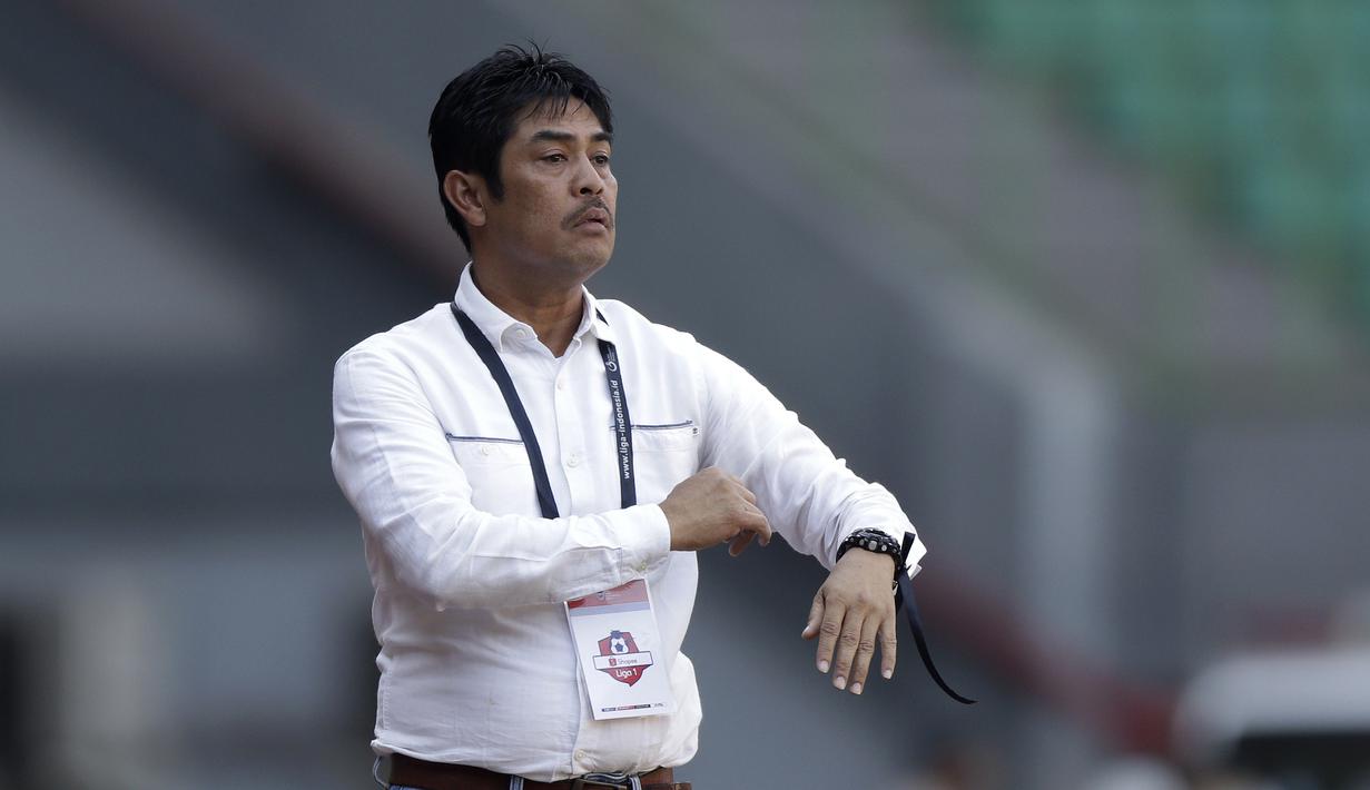 Pelatih Persela Lamongan, Nilmaizar, memperhatikan timnya saat melawan Perseru Badak Lampung pada laga Shopee Liga 1 di Stadion Patriot Chandrabhaga, Bekasi, Rabu (11/9). Perseru bermain imbang 1-1 atas Persela. (Bola.com/Yoppy Renato)