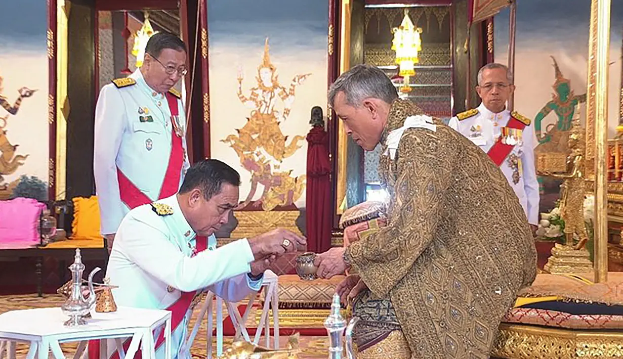 Maha Vajiralongkorn bersama PM Thailand Prayut Chan-O-Cha mengikuti upacara penobatan Raja baru Thailand di Bangkok (4/5/2019). Sebetulnya Vajiralongkorn telah naik takhta dua tahun lalu setelah meninggalnya sang ayah, raja Bhumibol Adulyade. (Photo by Handout/Thai Royal Household Bureau/AFP)
