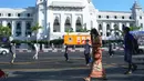 Orang-orang berjalan melewati Balai Kota sehari setelah militer Myanmar merebut kekuasaan, Yangon, Myanmar, Selasa (2/2/2021). Militer Myanmar menahan pemimpin yang terpilih secara demokratis Aung San Suu Kyi dan memberlakukan keadaan darurat satu tahun. (STR/AFP)