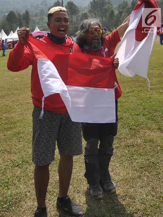 Atlet paralayang Indonesia, Jafro Megawanto bersama pelatih berselebrasi seusai babak nomor ketepatan mendarat pria cabang Paralayang Asian Games 2018 di Gunung Mas, Puncak, Jawa Barat, Kamis (23/8). Jafro sukses meraih emas. (Merdeka.com/Arie Basuki)