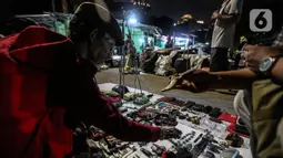 Pedagang melayani pembeli di Pasar Loak Kebayoran Lama, Jakarta, Rabu (3/11/2021). Pasar Loak Kebayoran Lama tetep eksis di tengah maraknya situs jual beli online. Barang dagangan yang dijual mulai dari pakaian, tas, aksesori hingga elektronik. (Liputan6.com/Johan Tallo)