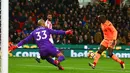Gelandang Liverpool, Sadio Mane berlari melewati kiper Stoke City, Lee Grant untuk mencetak gol pada pekan ke-14 Premier League di Bet365 Stadium, Kamis (30/11). Liverpool berhasil membantai Stoke City dengan skor 3-0. (Geoff CADDICK/AFP)
