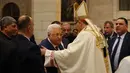 Presiden Palestina Mahmoud Abbas (tengah) mengucapkan selamat kepada Uskup Agung Pierbattista Pizzaballa, administrator apostolik Patriark Latin Yerusalem, dalam Misa Malam Natal di Kompleks Gereja Kelahiran Yesus, Bethlehem, Tepi Barat, Minggu (25/12/2022). Setelah dua tahun tutup karena COVID-19, jemaat kembali menghadiri ibadah tersebut kendati jumlahnya tidak sebanyak sebelum pandemi. (Ahmad Gharabli/Pool Photo via AP)