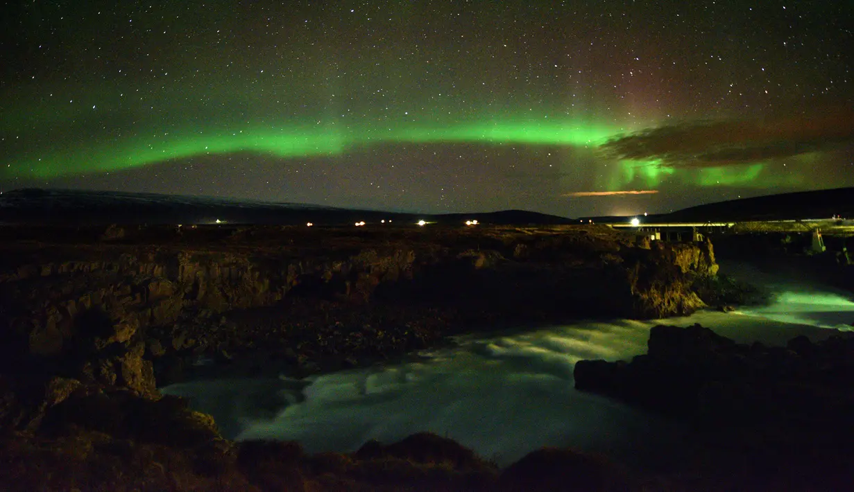Langit berhias aurora borealis atau Cahaya Utara terlihat di atas Thingeyjarsveit dan sungai Sprengisandur di Islandia, 14 Oktober 2018. Aurora borealis selalu terjadi di antara September dan Oktober; dan Maret dan April. (Mariana SUAREZ/AFP)