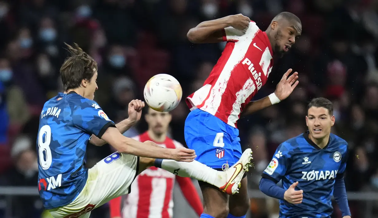 Gelandang Deportivo Alaves Tomas Pina berebut bola dengan gelandang Atletico Madrid Geoffrey Kondogbia dalam lanjutan La Liga Spanyol, Minggu (3/4/2022) dinihari WIB. Atletico Madrid menang telak dengan skor 4-1 atas Deportivo. (AP Photo/Manu Fernandez)