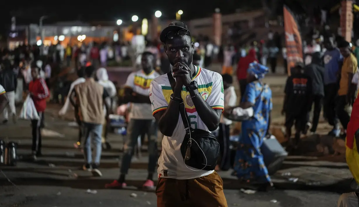 Reaksi suporter Senegal setelah menyaksikan laga babak 16 besar Piala Dunia 2022 saat tim kesayangan mereka melawan Inggris di Qatar, lewat layar video yang dipsang di fan zone di Dakar, Senin (5/12/2022) dini hari WIB. Senegal ditaklukkan Inggris dengan skor 0-3. (AP Photo/Leo Correa)