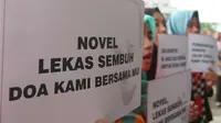 Sejumlah orang membawa poster ungkapan kepedulian saat mengikuti aksi peringatan 100 hari penyerangan Novel Baswedan di gedung KPK, Jakarta, Kamis (20/7). (Liputan6.com/Helmi Afandi)