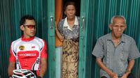 Pebalap sepeda Timnas Indonesia, Aiman Cahyadi beristirahat di teras toko warga saat berhenti di Barung-Barung Belantai dalam Etape 1 Tour de Singkarak 2015, Sabtu (3/10/2015). (Bola.com/Arief Bagus)