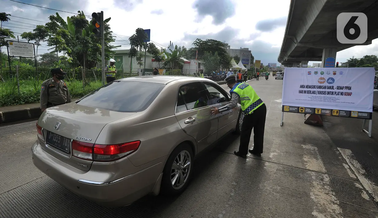 Petugas gabungan meminta mobil berpelat nomor ganjil untuk putar balik di Perempatan Yasmin, Kota Bogor, Sabtu (6/2/2021). Pemkot Bogor mulai menerapkan kebijakan ganjil-genap setiap akhir pekan untuk mengurangi mobilitas warga di tengah meningkatnya kasus positif COVID-19 (merdeka.com/Arie Basuki)