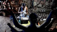Seorang perajin mengerjakan wajah patung tanah liat dewi Hindu Durga di sebuah lokakarya menjelang festival Durga Puja di Vashi di Navi Mumbai (23/9/2021). Durga Puja  adalah festival tahunan di Asia Selatan untuk memuja dewi Durga dari agama Hindu. (AFP/Indranil Mukherjee)