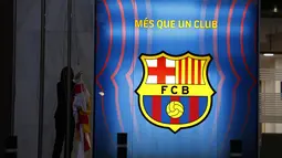 Seorang pekerja menurunkan bendera institusi dan klub sebelum kantor Barcelona tutup pada hari itu di stadion Camp Nou di Barcelona, Spanyol, Kamis (5/8/2021). Barcelona pada Kamis 5 Agustus 2021 bahwa Lionel Messi tidak akan bertahan dengan klub. (AP Photo/Joan Monfort)