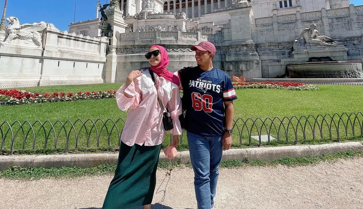 Berfoto bersama sang suami, Sheza Idris mengenakan kemeja pink dengan collar putih yang dipadukan midi skirt berwarna hijau. Lengkap dengan hijab berwarna pink dan sneakers. (instagram/shezaidris)