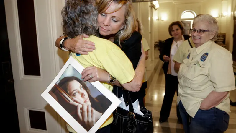 Debbie Ziegler memegang foto putrinya Brittany Maynard  yang telah meninggal setelah kebijakan hak untuk hidup dideklarasikan dan disetujui oleh Majelis Negara Bagian di Sacramento, California (AP)