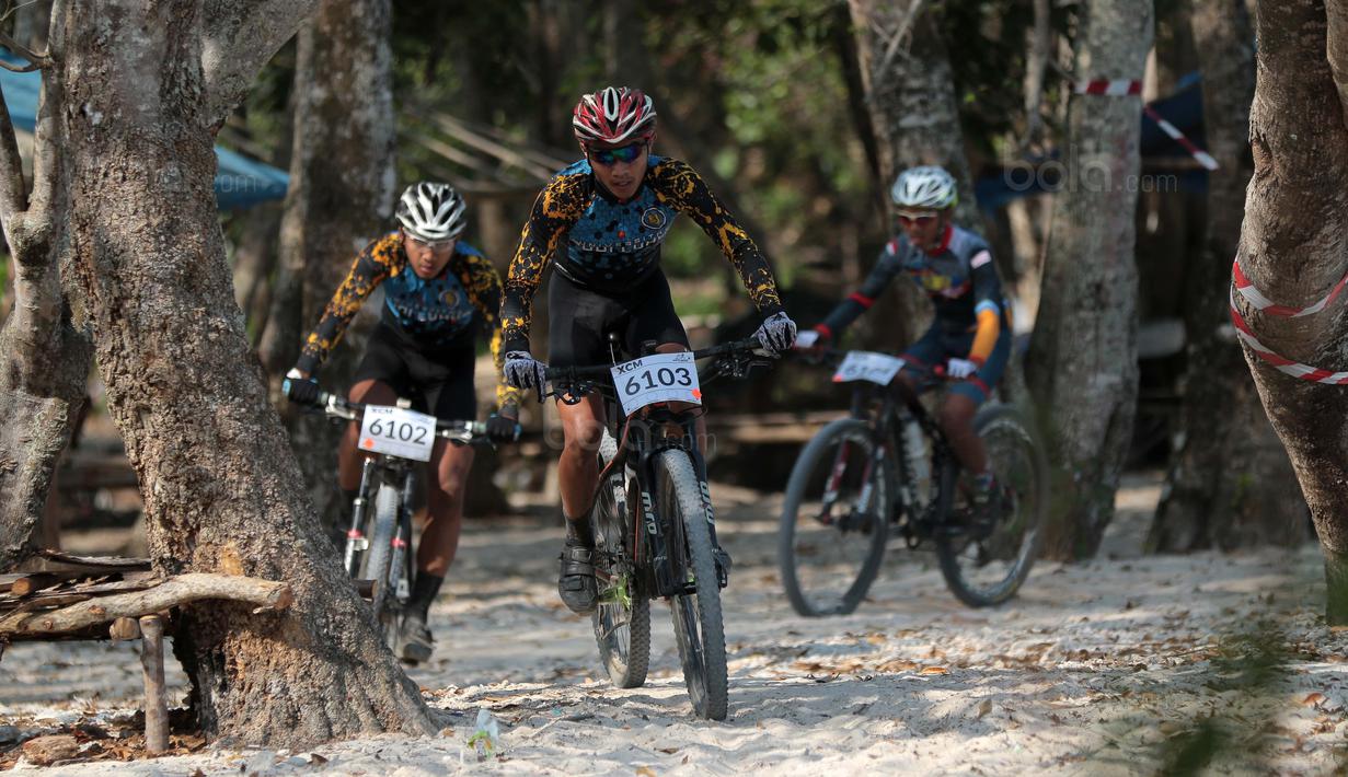 Para pebalap Mountain Bike Cross Country Marathon melintasi pepohonan pada Festival Pesona Tanjung Lesung 2017 di Tanjung Lesung, Banten (23/9/2017). MTB XCM tersebut menempuh jarak 48 km. (Bola.com/Nicklas Hanoatubun)