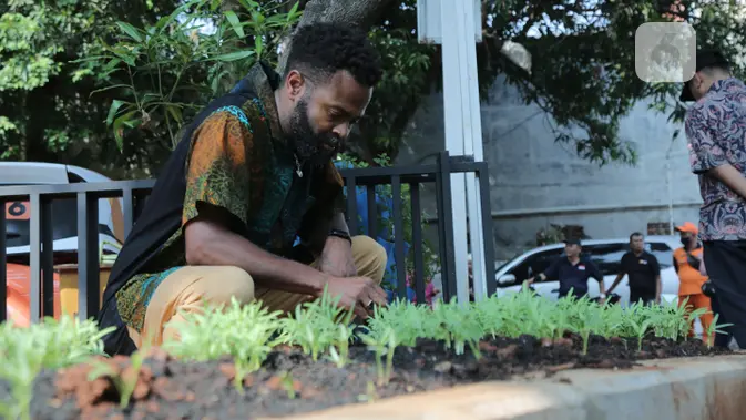 <p>Denzel Mitchell, praktisi urban farming (perkebunan kota) dari Maryland, Amerika Serikat. Ia sedang mengamati tanaman di kebun milik warga di KUA Cempaka Putih. Dok: Liputan6.com</p>