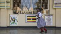 Seorang Siswa berlari di beranda koridor ruang kelas pada hari pertama pembukaan sekolah di Kampala, Uganda pada 10 Januari 2022. Sekolah-sekolah di Uganda dibuka kembali untuk siswa pada Senin (10/1), mengakhiri penutupan sekolah terlama di dunia akibat pandemi COVID-19. (Badru KATUMBA/AFP)