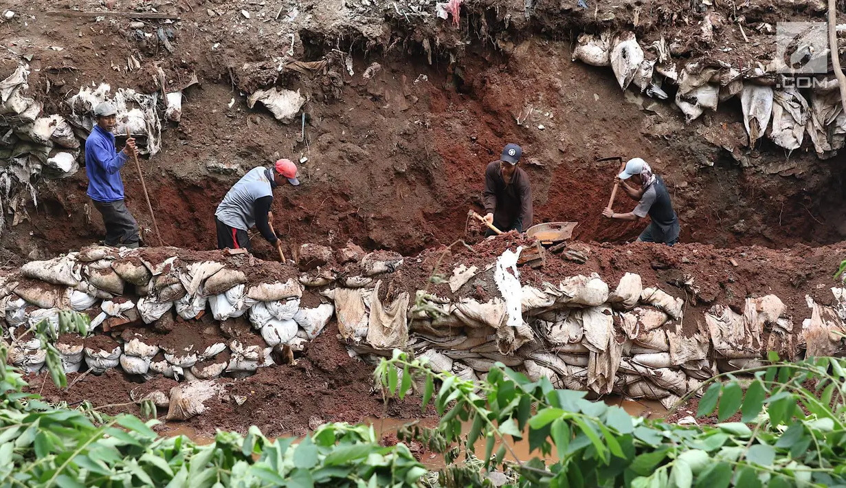 Pekerja membangun turap di bantaran Kali Setu Babakan, Jakarta, Sabtu (27/10). Turap dari tanah dan batu yang dimasukkan ke karung itu dibuat guna mencegah longsor yang sudah beberapa kali terjadi di kawasan tersebut. (Liputan6.com/Immanuel Antonius)