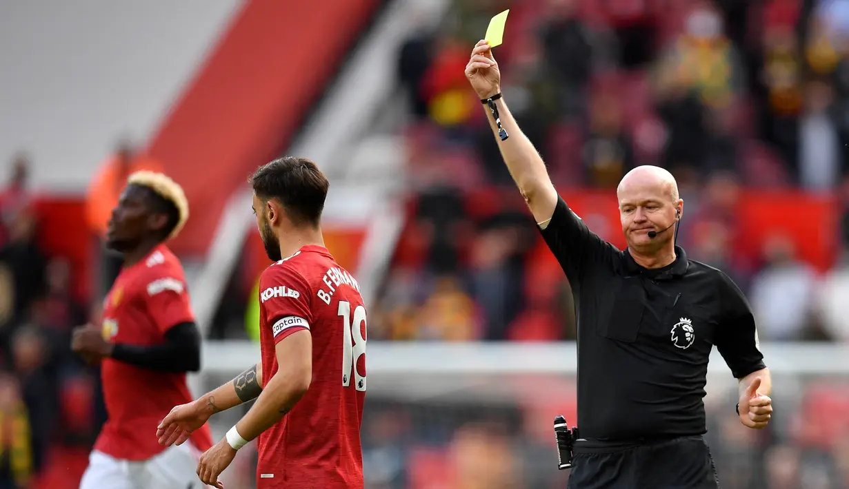Wasit Lee Mason memberikan kartu kuning kepada gelandang Manchester United, Bruno Fernandes saat melawan Fulham dalam laga lanjutan Liga Inggris 2020/2021 pekan ke-37 di Old Trafford Stadium, Rabu (18/5/2021). Manchester United bermain imbang 1-1 dengan Fulham. (AFP/Paul Ellis/Pool)